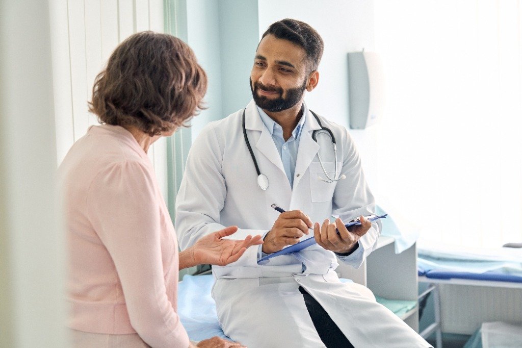 Doctor listening attentively to a patient with a clipboard during a medical consultation
